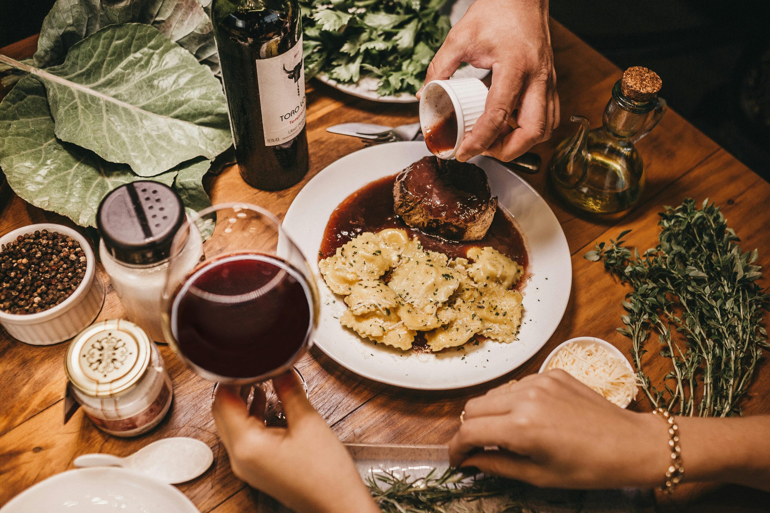 A delicious meal with wine, herbs, and richly seasoned meat prepared indoors.